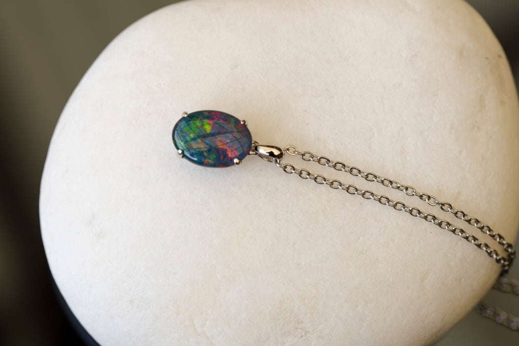 Opal pendant necklace on a white stone