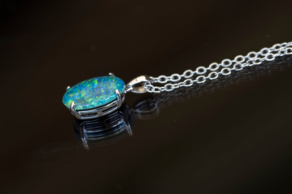 Opal pendant on a chain against a dark background