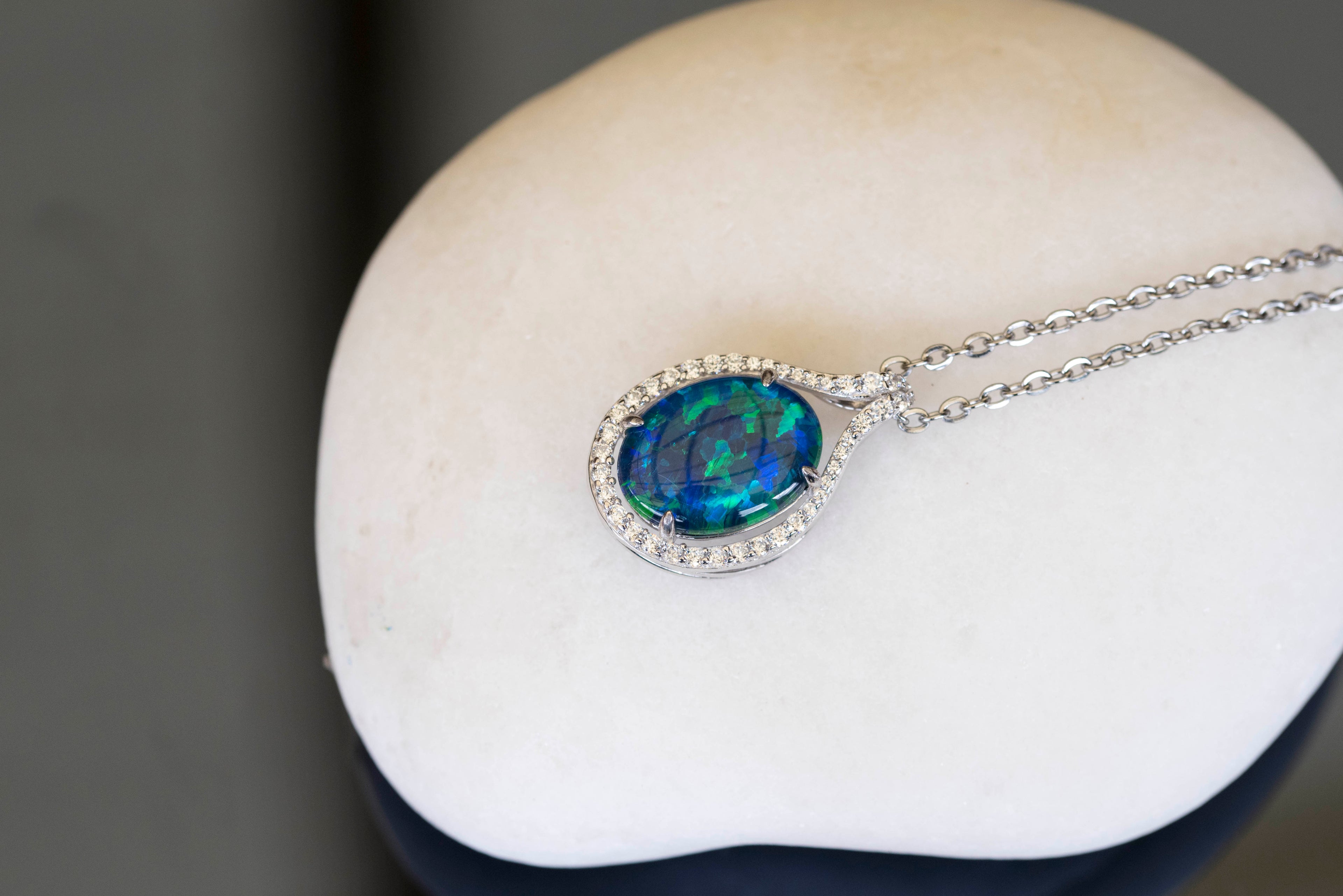 Opal pendant necklace on a white stone